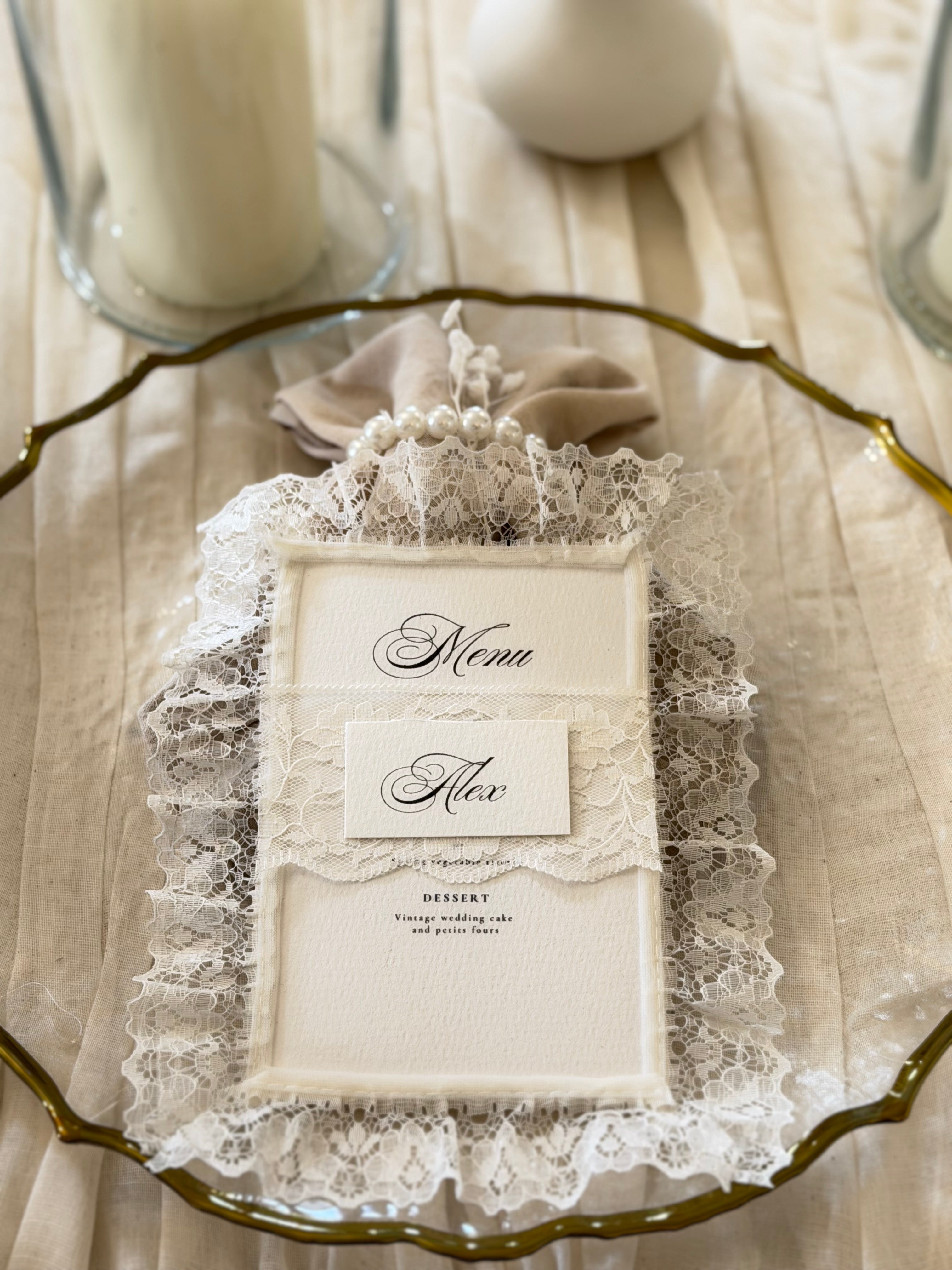 Stack of handmade lace-trimmed wedding menus